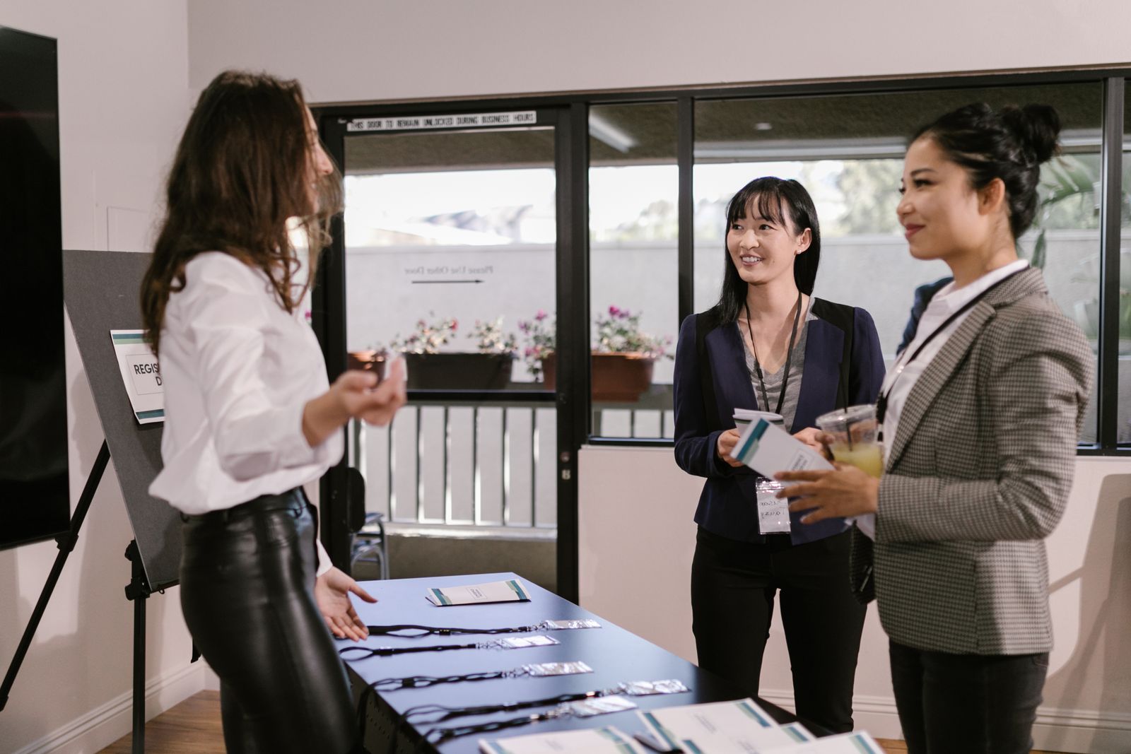 Hostesses welcoming guests at a conference registration desk, a key role when you hire hostesses in the UAE