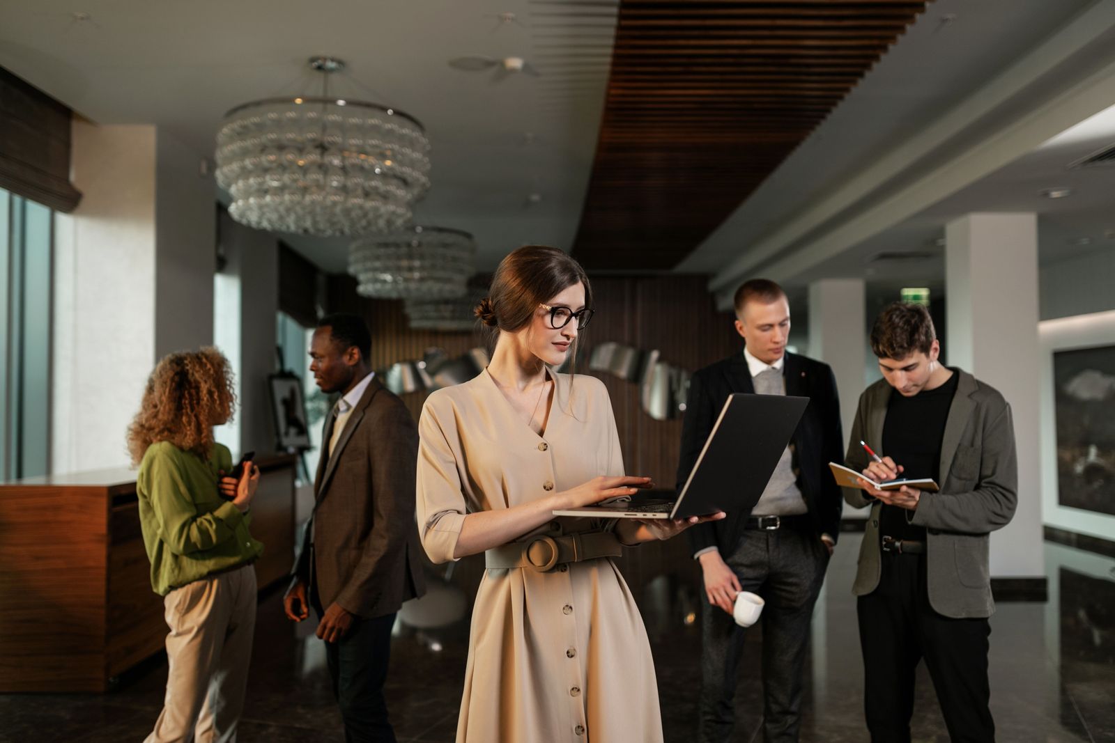 Conference staff with tablets and folders meeting delegates in the foyer