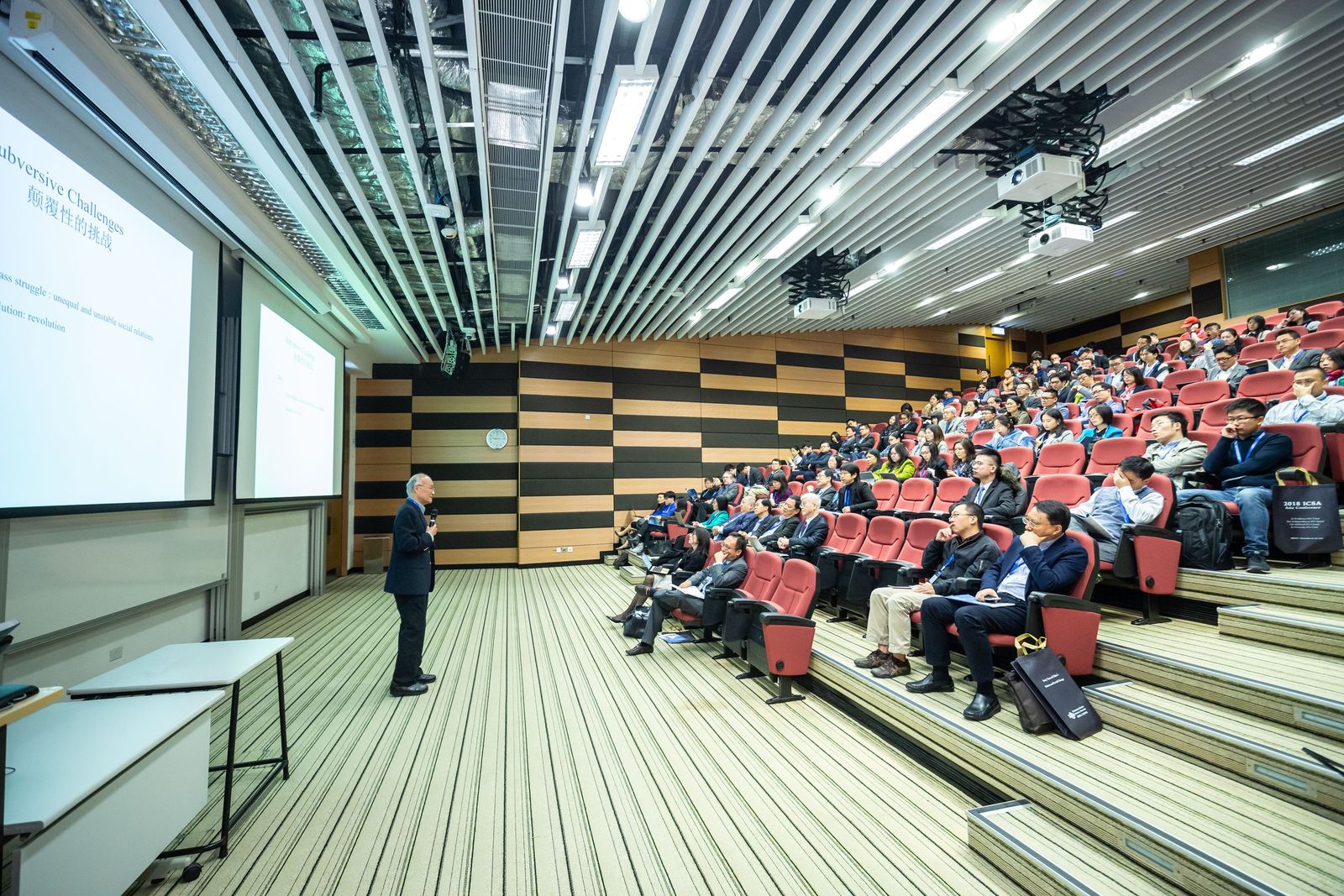 Speaker addressing delegates in a tiered conference auditorium