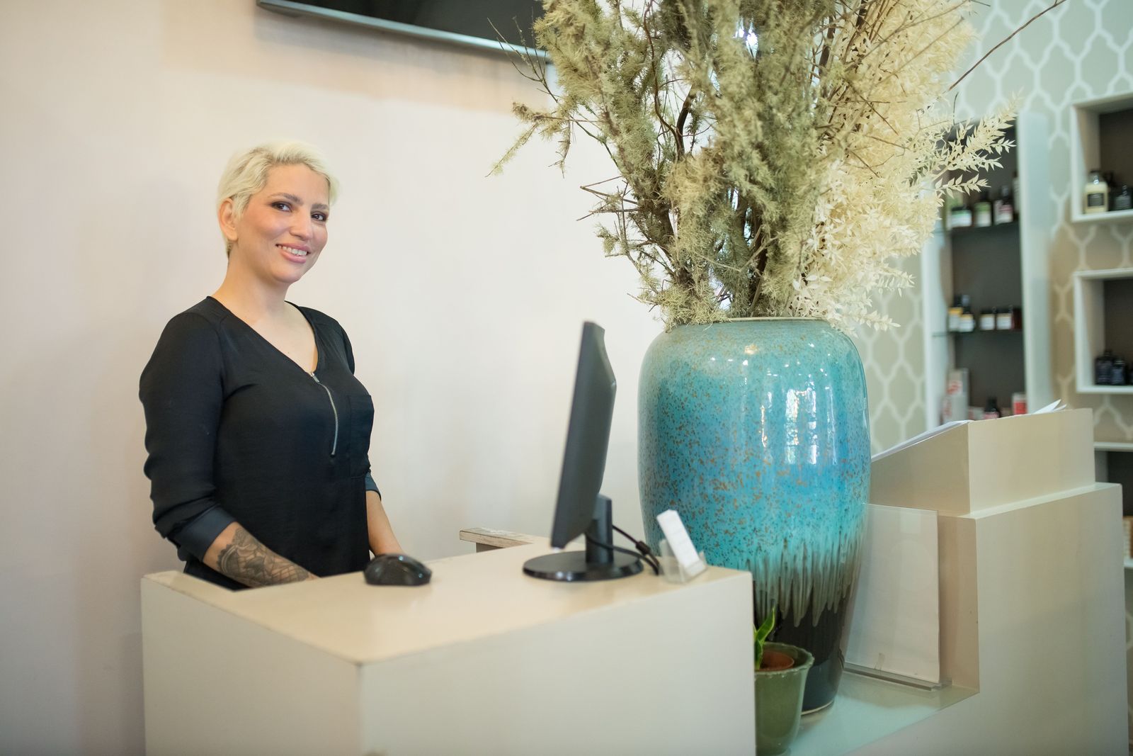 Smiling usher at a modern welcome desk ready to help guests