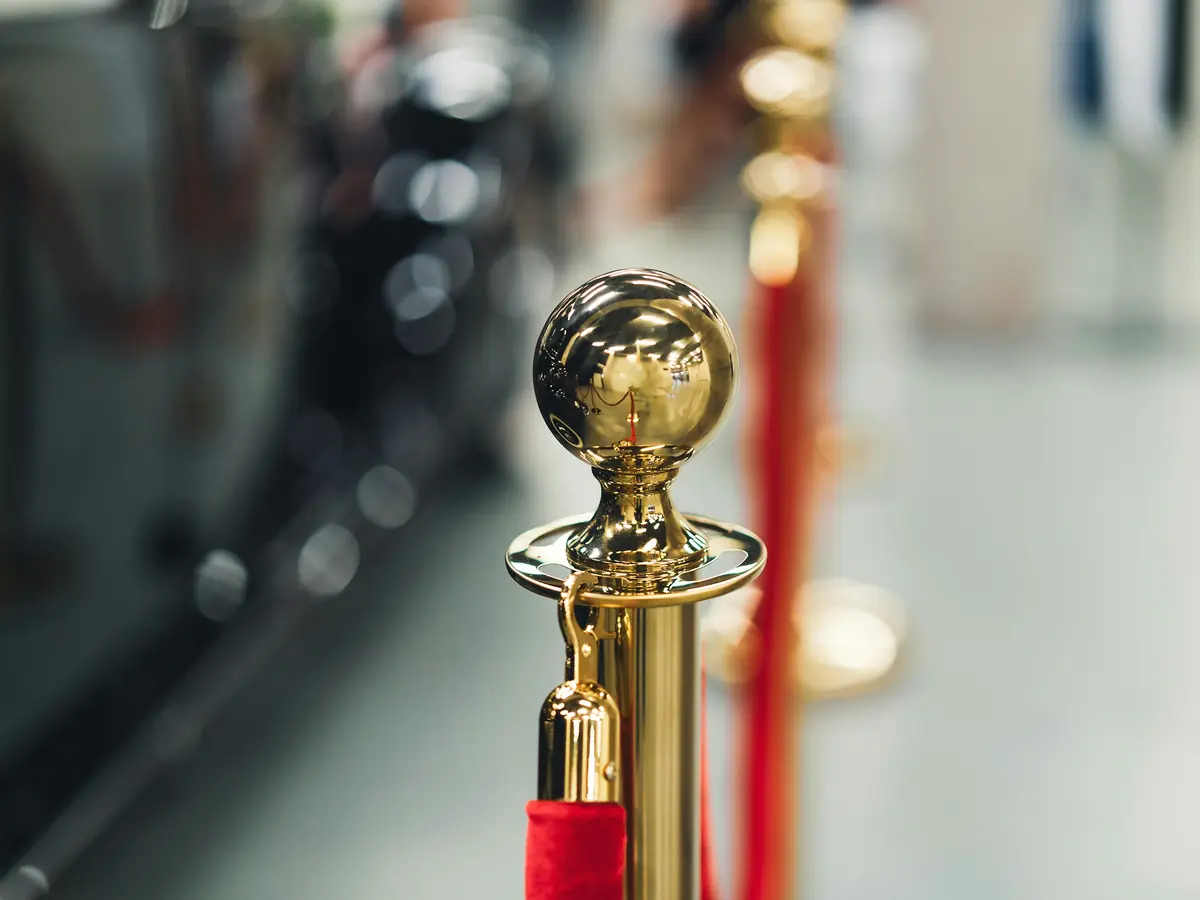 Gold rope stanchions marking a controlled event entrance